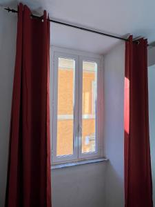 a window in a room with a red curtain at Charming Navona in Rome