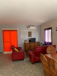 a living room with red chairs and a red couch at Villa duchesse in Sali Nianiaral