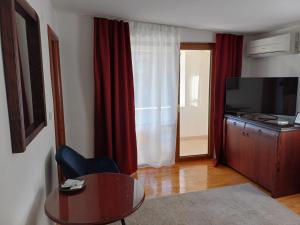 a living room with a table and a television at Villa Bella in Ohrid