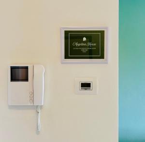 un téléphone sur un mur avec une pancarte sur celui-ci dans l'établissement Angelina House Cisano, à Cisano Bergamasco