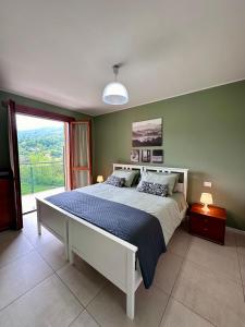 - une chambre avec un grand lit et une grande fenêtre dans l'établissement Angelina House Cisano, à Cisano Bergamasco