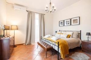 a bedroom with a bed with a yellow blanket on it at Country House nella Winery in Frascati