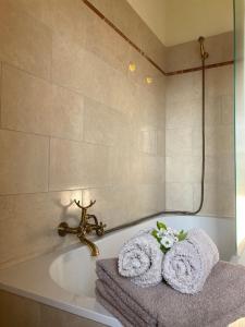 uma casa de banho com banheira e toalhas em Villa Verdicchio - B&B for winelovers em Cupramontana