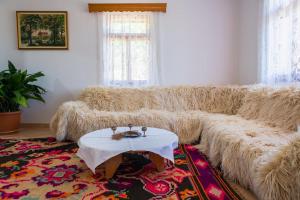 a living room with a large couch with a table at Bujtina Lazarat in Lazarat