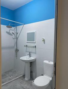 a bathroom with a white toilet and a sink at Casa 10 Ilhas in Assomada