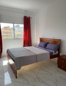- un lit dans une chambre dotée d'un rideau rouge dans l'établissement Casa 10 Ilhas, à Assomada