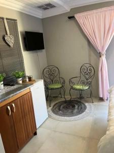 a living room with two chairs and a kitchen at Stellies Accommodation - Room 2 in Keetmanshoop