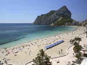 a beach with a lot of people and the ocean at Aparto Residence Galetamar in Calpe