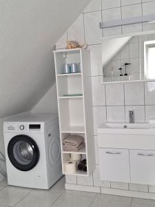 a laundry room with a washing machine and a sink at Ferienwohnung An der Karlskuppe in Eisenach