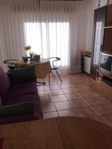 - un salon avec un canapé et une table dans l'établissement PORTOSIN Apartamento con piscina, playa, à Goyanes