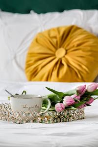 a tray with a cup and flowers on a bed at ARI Yellow Apartment - Panoramic View in Arad