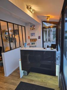 a room with a counter and some windows at Hôtel L'ideal le Mountbatten in Arromanches-les-Bains