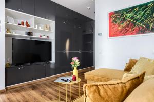 sala de estar con TV y sofá en ARI Yellow Apartment - Panoramic View, en Arad