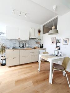 a white kitchen with a white table and chairs at Harmony apartments in Portorož