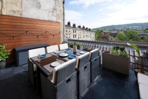 a patio with a table and chairs on a balcony at The Old Wine Merchant's House in Bath