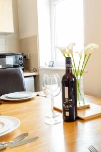 uma garrafa de vinho sentada numa mesa com um copo em Cosy & Compact Apartment in Swinton em Manchester