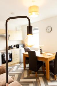 uma cozinha e sala de jantar com uma mesa e um candeeiro em Cosy & Compact Apartment in Swinton em Manchester