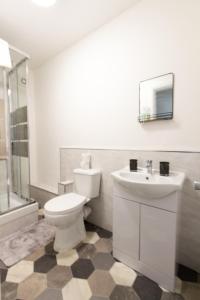 uma casa de banho branca com um WC e um lavatório em Cosy & Compact Apartment in Swinton em Manchester
