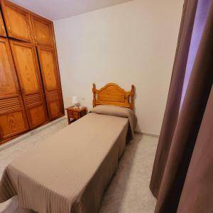 - une chambre avec 2 lits et une armoire en bois dans l'établissement Casa Pancho Lanzarote, à Playa Honda