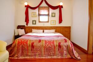 Schlafzimmer mit einem Bett und einem Fenster mit roten Vorhängen in der Unterkunft Aromatic Garden Villa La Poltrona in Nasu