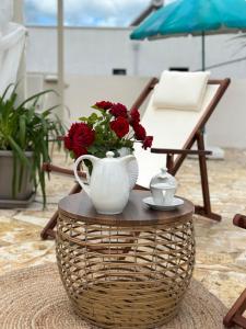 una mesa de centro con un jarrón con flores rojas. en Mediterranean Villa Old Town, en Vlorë