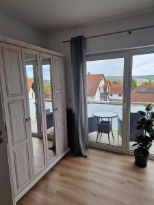 a living room with sliding glass doors and a table at Ferienwohnung An der Karlskuppe in Eisenach