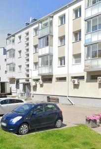a blue car parked in front of a building at nr 30 with view balcony in Ramučiai