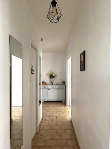 聖普列斯特的住宿－Appartement de 80m2 aux portes de Lyon avec ascenseur, balcon, parking，走廊设有白色墙壁和瓷砖地板