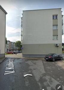 un coche aparcado en un aparcamiento al lado de un edificio en nr 30 with view balcony, en Ramučiai