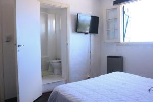 a bedroom with a bed and a television on a wall at Playa Grande Dos Ambientes in Mar del Plata