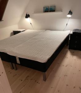 Skønt byhus midt i Marstal. في Marstal: سرير كبير في غرفة بها مصباحين