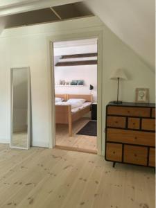 - une chambre avec un lit, un miroir et une commode dans l'établissement Skønt byhus midt i Marstal., à Marstal