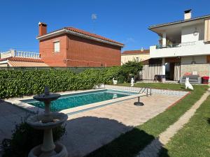 a swimming pool in a yard next to a house at Piso superior tranquilo terraza y vistas A 45 min de Barcelona in Cunit