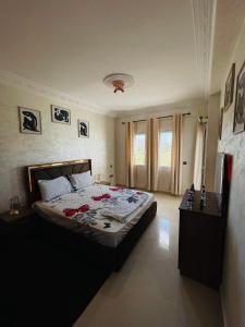 a bedroom with a large bed with red roses on it at Achakar playa - piscine - wifi in Tangier +3 photos