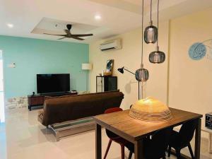 een woonkamer met een tafel en een bank bij Jemhaus Marina View [Netflix & LG Water Purifier] in Lumut