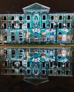 un edificio cubierto de graffiti con su reflejo en el agua en Bremen City en Bremen