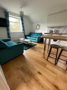 ein Wohnzimmer mit einem blauen Sofa und einem Tisch in der Unterkunft Crannach House in Ballater