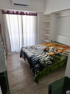 a bedroom with a bed with a zebra blanket at Monoambiente con balcón in Buenos Aires