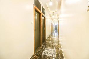 a hallway with a tile floor and a door at New Axis International By Glitz Hotels in Mumbai