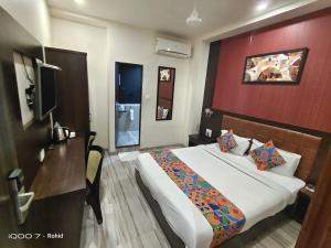 Habitación de hotel con cama y pared roja en New Axis International By Glitz Hotels en Bombay