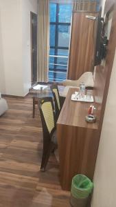een kamer met een tafel en stoelen in een kamer bij New Axis International By Glitz Hotels in Mumbai