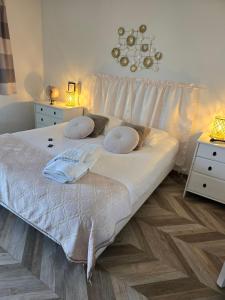 a bed with white sheets and pillows in a bedroom at Hôtel L'ideal le Mountbatten in Arromanches-les-Bains