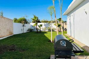 - un barbecue dans une cour à côté d'une maison dans l'établissement Villa Darline Maison Design Piscine chauffée, à Essaouira
