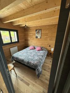 - une chambre avec un lit dans une cabane en bois dans l'établissement Chalet Le Bisolet, à Les Déserts