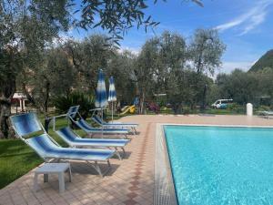 un gruppo di sedie a sdraio blu accanto alla piscina di Hotel Casa Chincarini a Malcesine