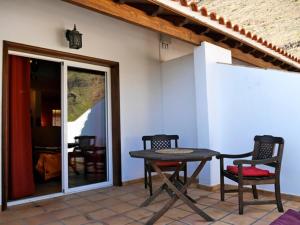 a patio with a table and chairs in front of a house at La Galería in Calera