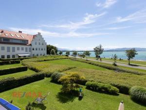 a large garden in front of a building next to the water at Kaiserstrand Apartment Bodensee - Lake Constance, Lochau - Bregenz, Austria in Lochau
