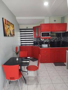 a kitchen with red cabinets and a table and chairs at Gated Riverside Studio Apartment in San Juan