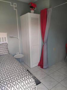 a bedroom with a bed and a red curtain at Gated Riverside Studio Apartment in San Juan