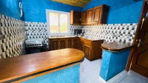 a kitchen with blue walls and wooden cabinets at Residence les Berniers in Nianing